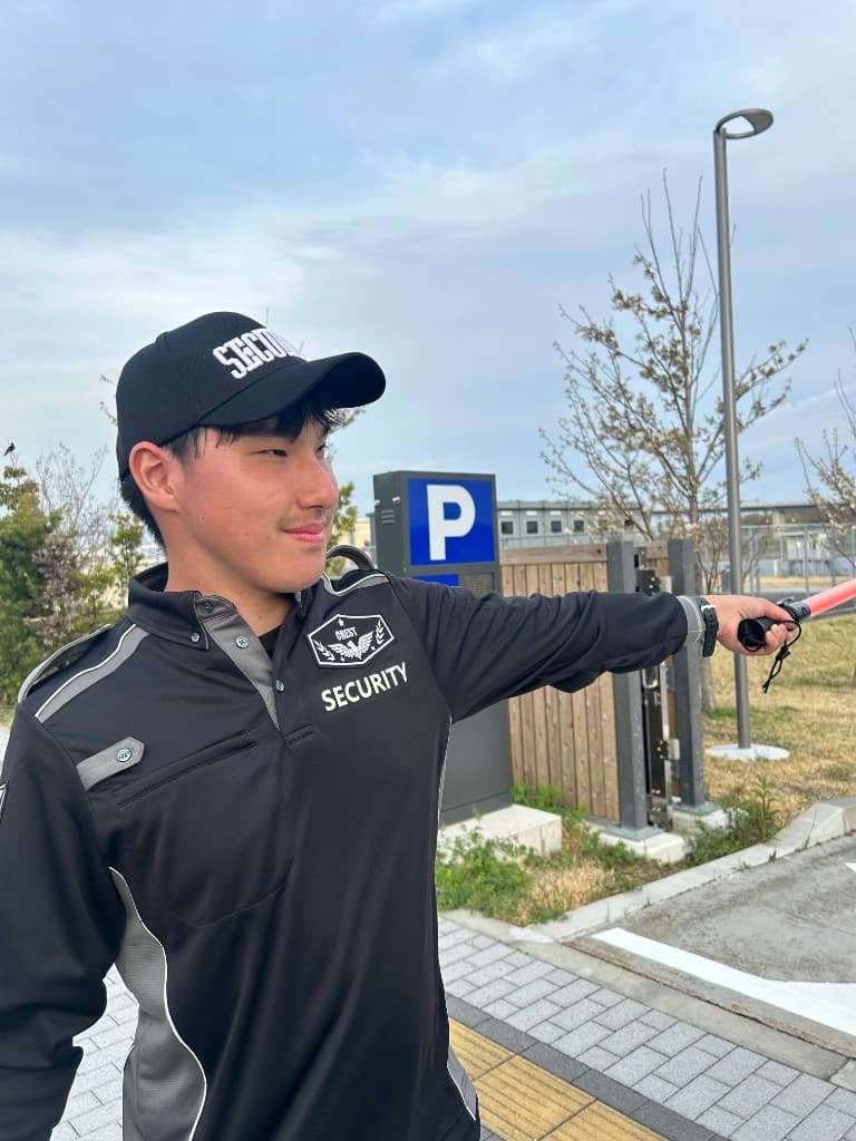 誘導棒で案内にあたる警備スタッフ